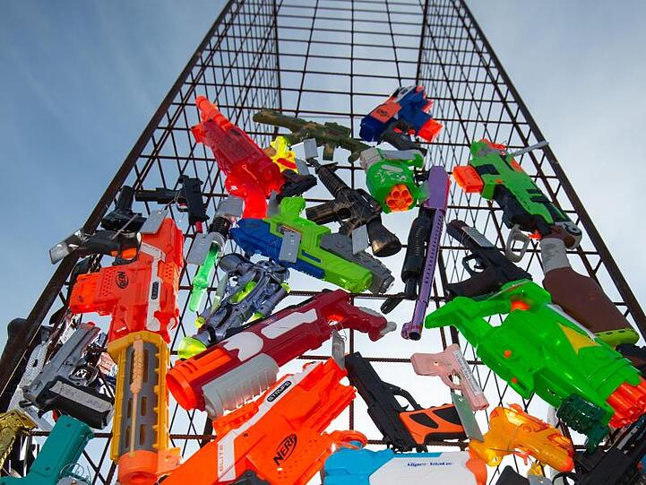 Eine Skulptur aus Spielzeugwaffen befindet sich im Aufbau. Foto: Timm Schamberger/dpa