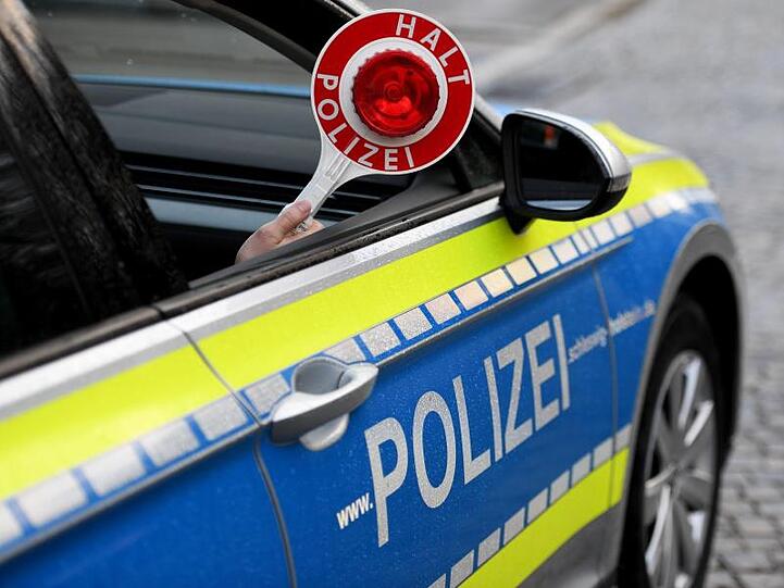 Eine Haltekelle wird aus einem Streifenwagen gehalten. Foto: Carsten Rehder/dpa/Symbolbild