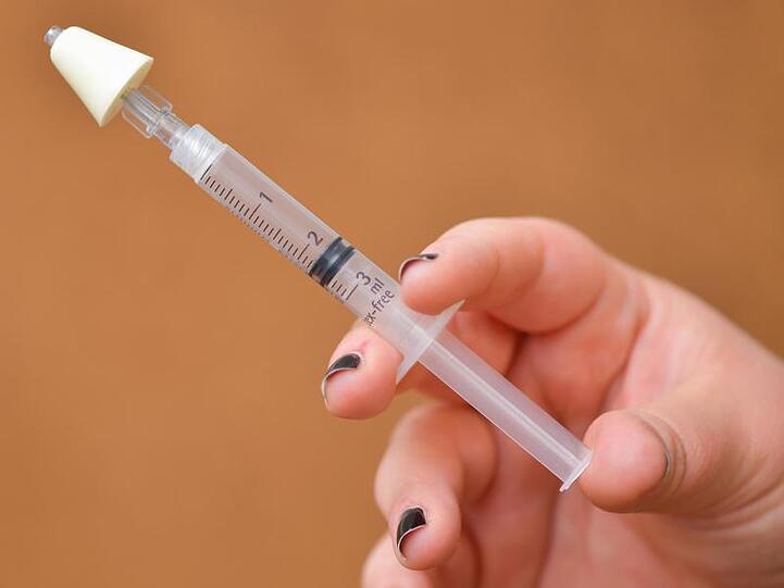 Eine Hand hält eine als Nasenspray einsetzbare Spritz mit dem Medikament Naloxon. Foto: Uwe Anspach/dpa/Archivbild