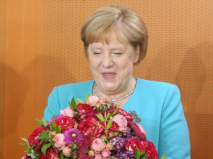 Angela Merkel hält zu Beginn der Kabinettssitzung im Bundeskanzleramt einen Blumenstrauß in den Händen, den sie von den Kabinettskollegen überreicht bekam.
