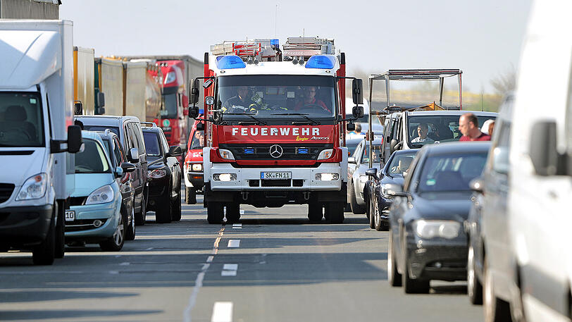 Ein Einsatzfahrzeug der Feuerwehr fährt durch eine Rettungsgasse. (Archivbild)