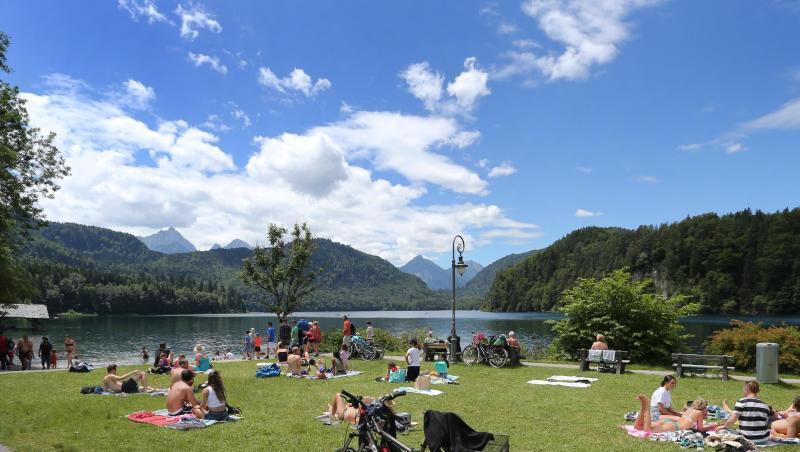 Ausflügler genießen den Sonnenschein am Ufer des Alpsees. Foto: Karl-Josef Hildenbrand/dpa Ausflügler genießen den Sonnenschein am Ufer des Alpsees. Foto: Karl-Josef Hildenbrand/dpa