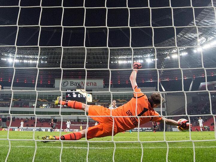 Leverkusens Torwart Lukas Hradecky hält einen Ball.