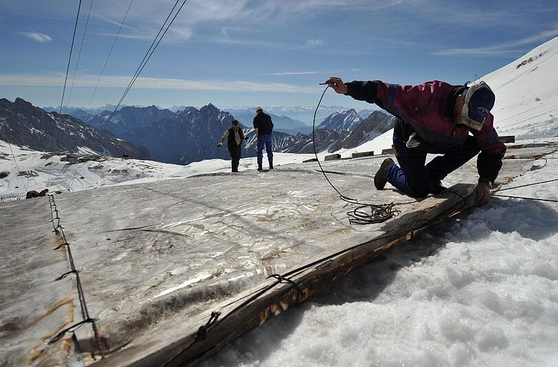 Rettungsaktion für die Zugspitze: Arbeiter decken den Gletscher mit Planen ab.