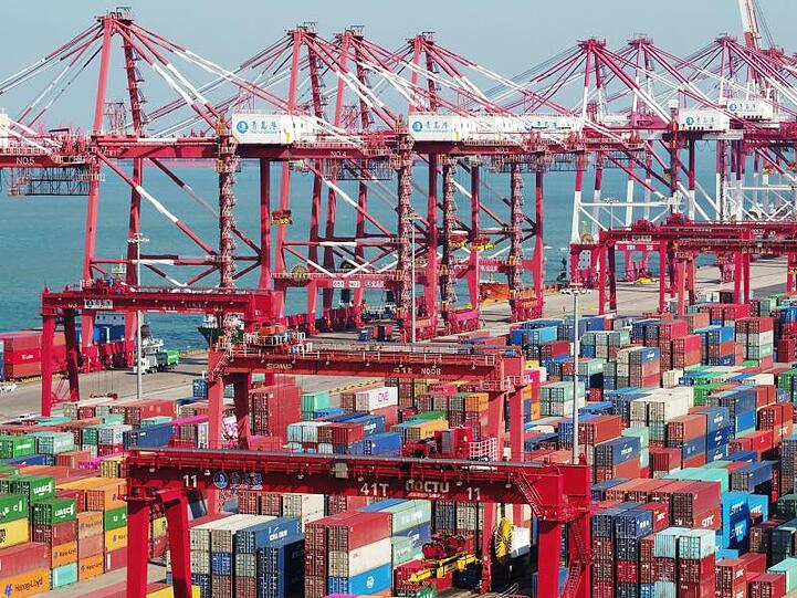 Im chinesischen Hafen Qingdao stehen Container und Containerbrücken.