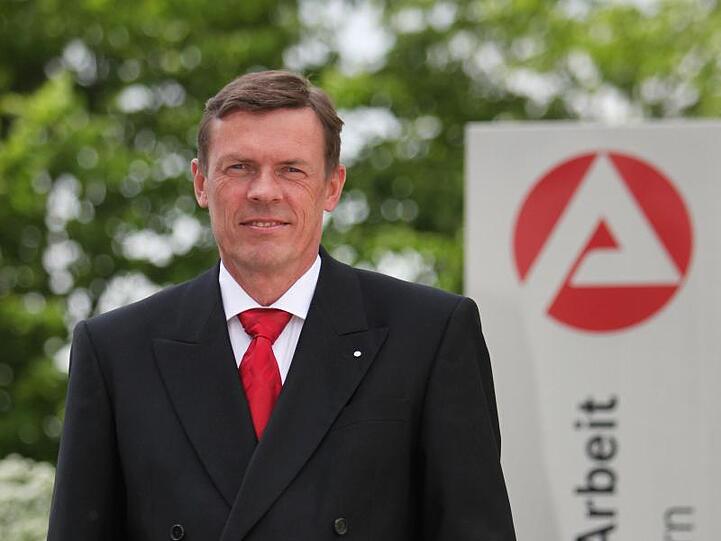 Ralf Holtzwart steht vor dem Logo der Agentur für Arbeit. Foto: Daniel Karmann/Archiv