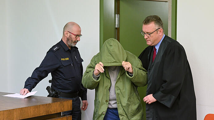 Der Angeklagte (M) wird von seinem Anwalt, Olaf Groborz (r) und einem Polizeibeamten in den Gerichtssaal geführt. Der 85-Jährige muss sich wegen Totschlags an seiner pflegebedürftigen Frau verantworten.