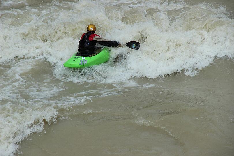 Hochwasser für die einen, perfekte Wellen für die anderen. Waghalsig tummeln sich Sportler in der Isar.