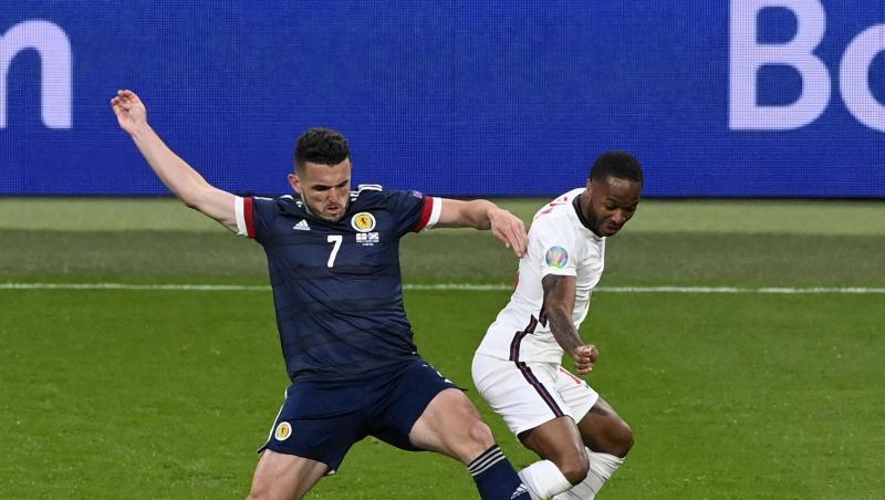 Der Schotte John McGinn (l) ist im Zweikampf vor Raheem Sterling am Ball.