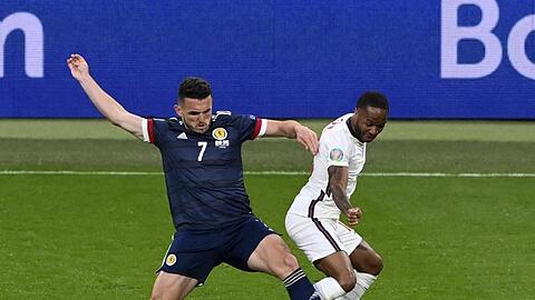 Der Schotte John McGinn (l) ist im Zweikampf vor Raheem Sterling am Ball.