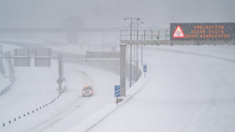 Ein Rettungsfahrzeug fährt auf der leeren, schneebedeckten Schnellstraße M-30 durch Madrid.