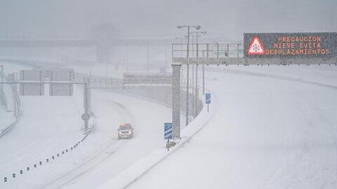 Ein Rettungsfahrzeug fährt auf der leeren, schneebedeckten Schnellstraße M-30 durch Madrid.