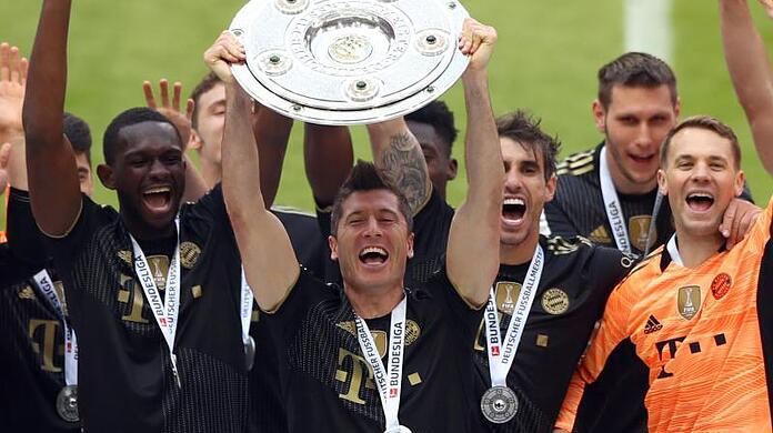 Robert Lewandowski (M) jubelt mit der Meisterschale über den Gewinn der Deutschen Meisterschaft.