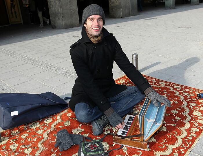 Mark Janken (28), Straßenmusiker: "Etwa zweimal wöchentlich bin ich hier und spiele alte indische Mantra-Musik. Weil der Teppich, auf dem ich sitze, viel Kälte durchlässt, habe ich mir eine Isomatte drunter gelegt. Ich trage Angoraunterwäsche und drei Paar Wollsocken. Auch eine Thermoskanne Ingwertee hilft. Außerdem habe ich zwei verschiedene Handschuhe: Links mit und rechts ohne Fingerschutz. Mit der rechten Hand muss ich ja die Tasten drücken können. Drei Stunden lang musiziere ich hier. Einmal wärme ich mich im Kaufhaus auf. Wenn ich nach Hause komme, hat meine Frau hoffentlich etwas Warmes gekocht. Und falls mir sehr kalt ist, nehme ich ein heißes Bad."