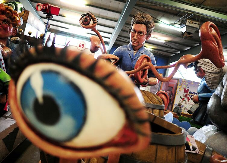 Der Motivwagen "Der Aufdecker" des Mainzer Carneval-Verein zeigt den Whistleblower Edward Snowden, der mehrere Fässer öffnet, aus denen Augen und Ohren hervorkommen.