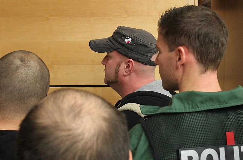 Neonazi Martin Wiese steht am 25.09.2013 im Landgericht Würzburg hinter einem Polizeibeamten. Im Berufungsprozess gegen den 37-Jährigen wegen Volksverhetzung und Bedrohung wird heute das Urteil erwartet.