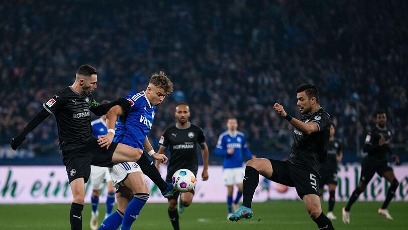 Schalkes Keke Topp (M) kämpft mit Greuter Fürths Branimir Hrgota (l) und Oussama Haddadi um den Ball.