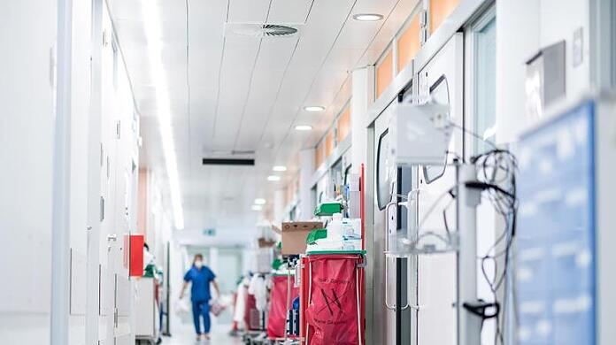 Eine Pflegekraft geht auf einer Intensivstation über den Flur.