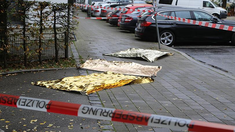 Rettungsdecken liegen nach der Messerattacke auf dem Boden am Rosenheimer Platz.