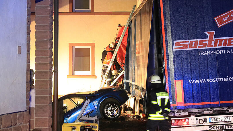 Der Sattelzug rammte ein geparktes Auto und donnerte gegen ein Haus. Die Rettung des Fahrers gestaltete sich extrem kompliziert.