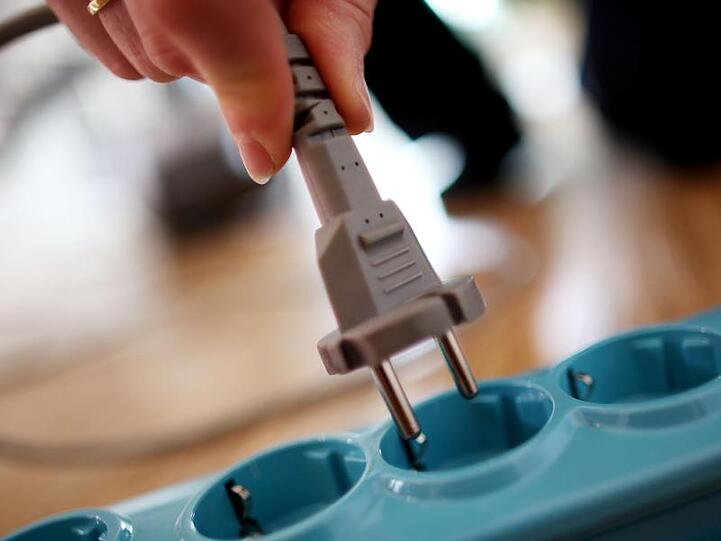 Ein Stecker wird in die Steckdose gesteckt.