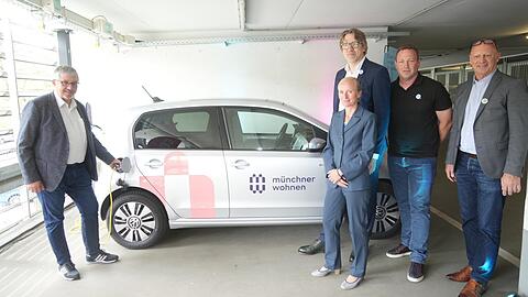 V. l.: Christian Müller, Susanne Kraus, Georg von Oepen, Daniel Heidemann und Gabriel Ringelstetter von der Münchner Wohnen laden ein E-Auto auf einem elektrifizierten Stellplatz der Hochgarage an der Bad-Schachener-Straße am Innsbrucker Ring.