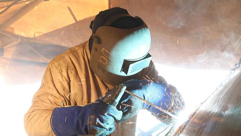 Eine Person verschwei&szlig;t zwei Teilst&uuml;cke einer Erdgas-Pipeline in Norddeutschland. In Bayern und Europa k&ouml;nnte in der Zukunft durch die R&ouml;hre auch CO 2 transportiert werden. Zumindest gibt es umfangreiche Planungen daf&uuml;r.