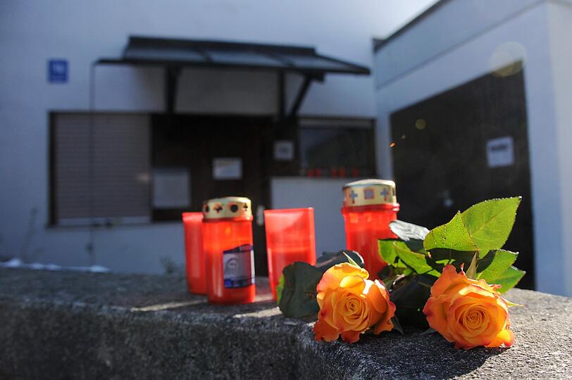 Vor dem Haus des Mesners haben Trauernde Rosen und Kerzen abgelegt. Die Tat geschah in der Küche im Erdgeschoss, der Rolladen ist heruntergelassen.