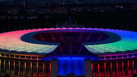 Das Olympiastadion in Berlin ist in Regenbogenfarben beleuchtet.