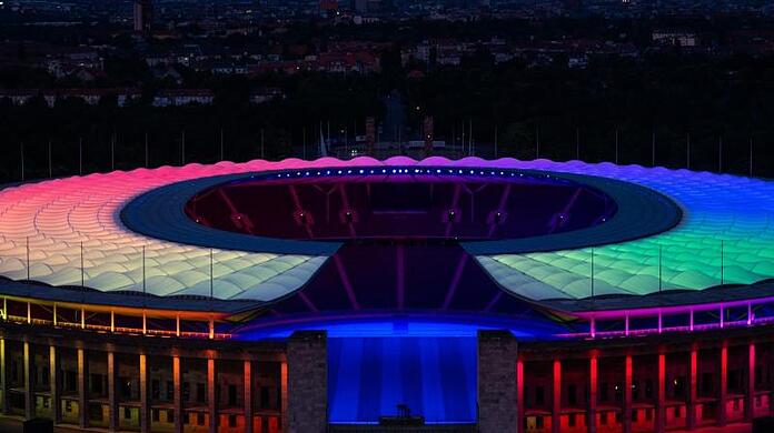 Das Olympiastadion in Berlin ist in Regenbogenfarben beleuchtet.