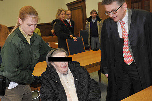 Verteidiger Alexander Seifert begrüßt im Blitzlichtgewitter die Drogen-Dealerin Christa K. (81). Sie wurde im Rollstuhl aus der U-Haft zum Prozess gebracht, ein Notarzt wachte an ihrer Seite.