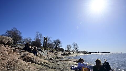 Menschen genießen in Helsinki die Frühlingssonne.