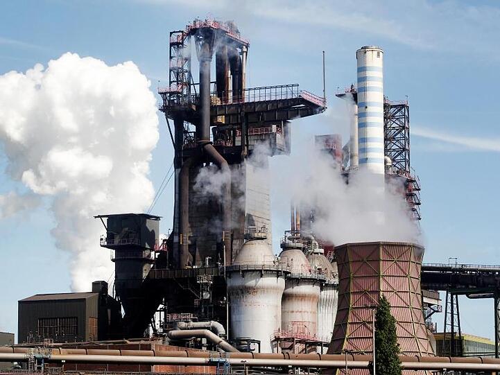 Wasserdampfwolken umgeben zwei Hochöfen bei Thyssenkrupp in Duisburg.