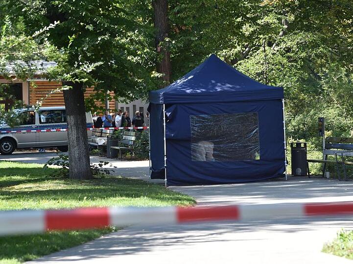 Polizisten sichern in einem Faltpavillon Spuren am Tatort.