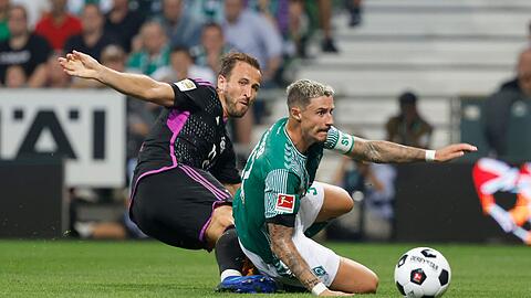 Bremens Marco Friedl (l) und Bayerns Harry Kane kämpfen um den Ball.