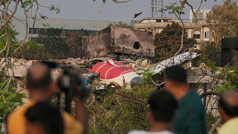 Menschen betrachten die Wrackteile des am Donnerstag (12.06.2025) abgestürzten Flugzeugs von Air India. (Foto Archiv)