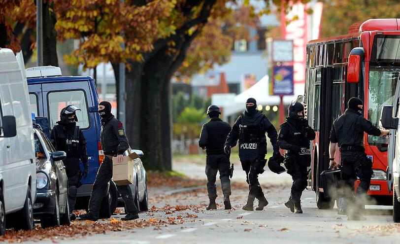 Mit erhobenen Händen kommt ein Mann auf die SEK-Beamten zu, im Hintergrund lauern Heckenschützen der Polizei. Die Beamten nehmen den Mann fest, es ist aber nicht der Täter, der sich in einem Imbiss in Freiburg veschanzt hat.