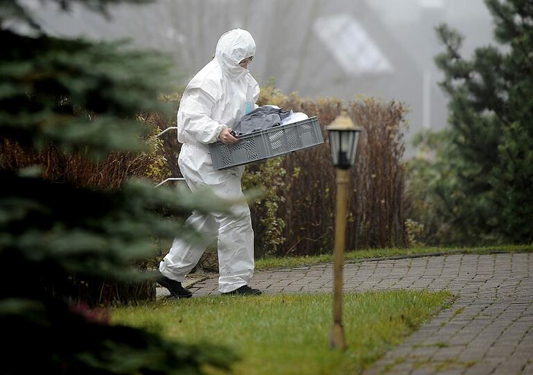 Eine Mitarbeiterin der Spurensicherung trägt einen Korb mit Beweismaterial aus der Kirche.