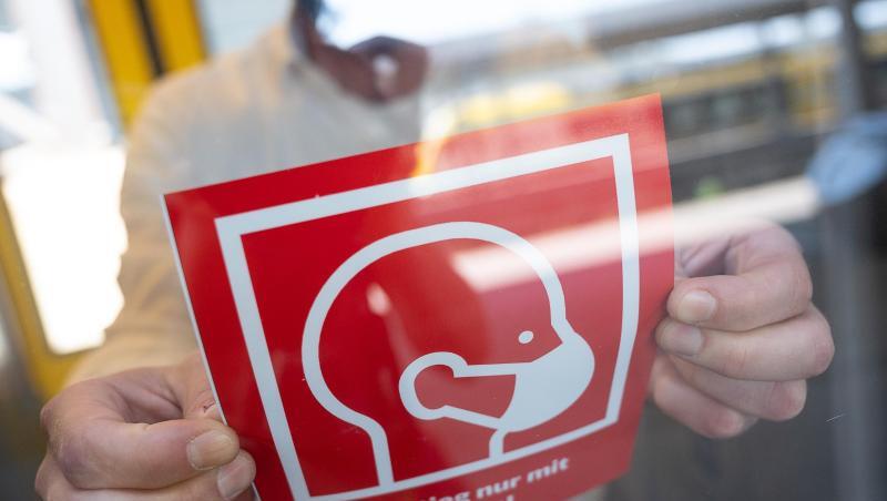 Ein Mann befestigt ein Informationsschild zur Maskenpflicht:. Foto: Sebastian Gollnow/dpa/Symbolbild Ein Mann befestigt ein Informationsschild zur Maskenpflicht:. Foto: Sebastian Gollnow/dpa/Symbolbild