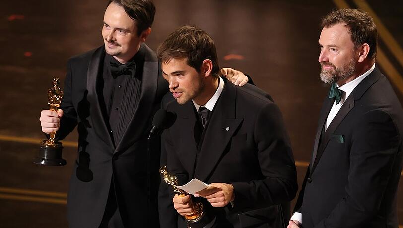 David Breschel, Sam A. Davis und Jack Piatt nehmen ihre Oscar-Statuetten f&uuml;r "The Singers" in Empfang.