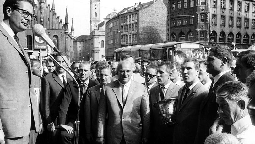 Die Löwen bei ihrer Rückkehr aus Stuttgart 1964, wo sie das Endspiel gegen Eintracht Frankfurt mit 2:0 gewannen und zum zweiten Mal Pokalsieger wurden. Bild oben: Oberbürgermeister Dr. Hans Jochen Vogel (l) begrüßt die Spieler auf dem Marienplatz. Zu sehen sind (v.l.): Peter Grosser, Berti Kraus, Löwen-Präsident Adalbert Wetzel Hans Auernhammer, Rudi Brunnenmeier, Petar Radenkovic und Otto Luttrop. Bild unten: Beim Autocorso stehen im Wagen (v.l.): Adalbert Wetzel, Kapitän Brunnenmeier und Trainer Max Merkel. Die Löwen bei ihrer Rückkehr aus Stuttgart 1964, wo sie das Endspiel gegen Eintracht Frankfurt mit 2:0 gewannen und zum zweiten Mal Pokalsieger wurden. Bild oben: Oberbürgermeister Dr. Hans Jochen Vogel (l) begrüßt die Spieler auf dem Marienplatz. Zu sehen sind (v.l.): Peter Grosser, Berti Kraus, Löwen-Präsident Adalbert Wetzel Hans Auernhammer, Rudi Brunnenmeier, Petar Radenkovic und Otto Luttrop. Bild unten: Beim Autocorso stehen im Wagen (v.l.): Adalbert Wetzel, Kapitän Brunnenmeier und Trainer Max Merkel.