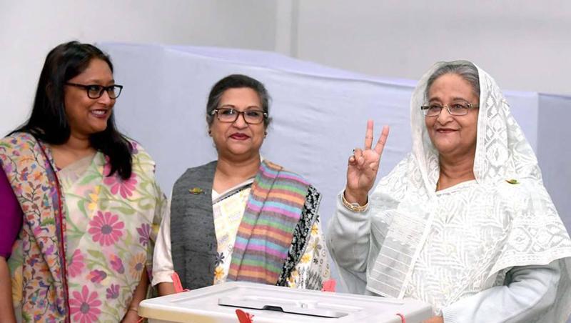 Sie kann weiter regieren: Sheikh Hasina (r.), Premierministerin von Bangladesch, macht im Wahllokal das Siegeszeichen. Sie kann weiter regieren: Sheikh Hasina (r.), Premierministerin von Bangladesch, macht im Wahllokal das Siegeszeichen.