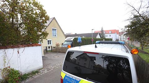 Ein Polizeiauto steht vor einem Wohnhaus im Ort.