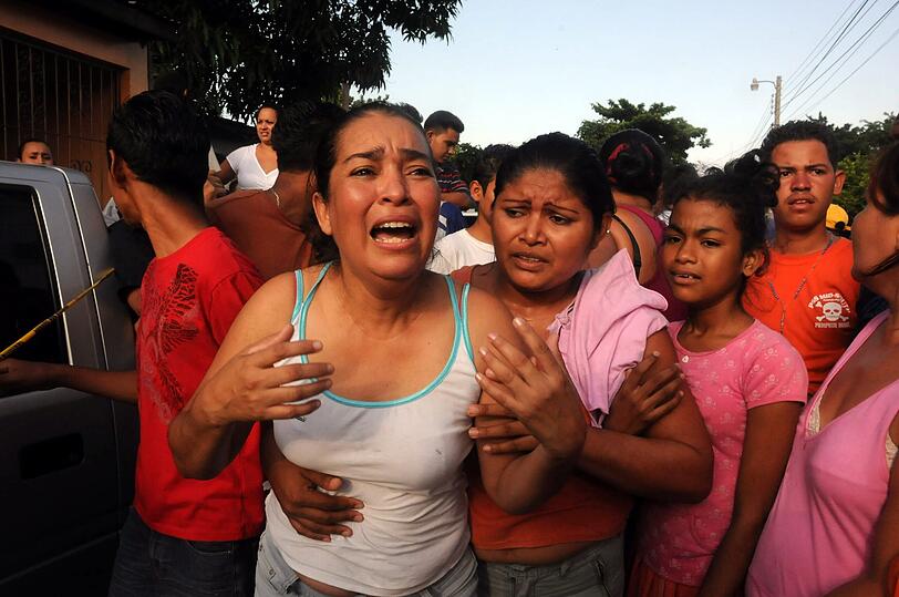 Angehörige der Opfer weinen um die Toten nach dem Überfall auf eine Schuhfabrik in Honduras