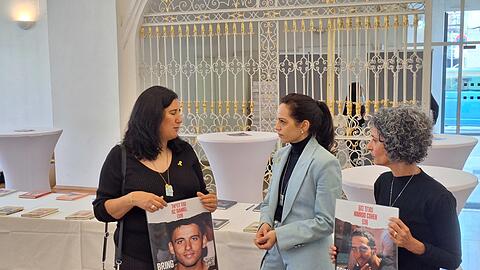 Die Mütter zweier Geiseln, Meirav Daniel (l.) und Viki Cohen (r.), unterhalten sich mit der Künstlerin Inbar Hasson (M.), die das Projekt "Coming Home Soon" ins Leben gerufen hat.