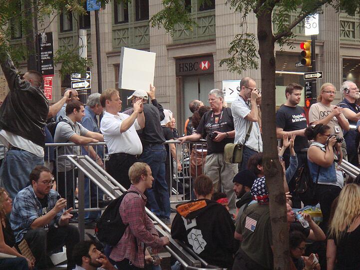 Viele New Yorker bleiben auf dem Weg zur Arbeit stehen und schießen Fotos. Die Besetzer an der Wall Street sind zur Attraktion geworden.