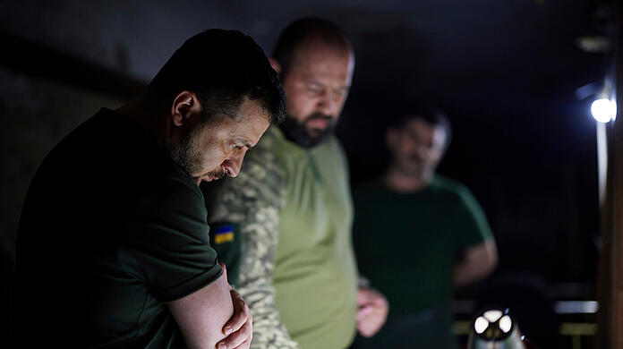 Auf diesem vom Pressebüro des ukrainischen Präsidenten zur Verfügung gestellten Foto hört Wolodymyr Selenskyj, Präsident der Ukraine, einem Bericht eines Soldaten nahe der Frontlinie in der Region Donezk.
