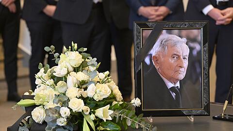 Neben den Kondolenzbuch zum Tod von Alois Glück im Bayerischen Landtag steht ein Bild des Verstorbenen.