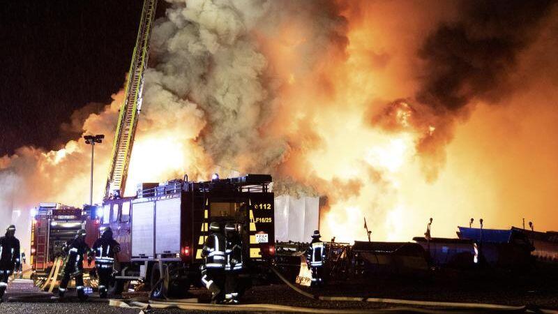 Feuerwehrleute löschen den Brand einer Lagerhalle in Tittling. Foto: Stefan Plöchinger/zema-medien/dpa