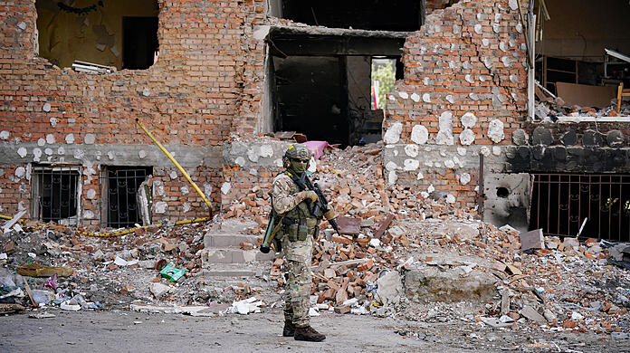 Ein ukrainischer Soldat vor einem zerstörten Gebäude. (Archivbild)